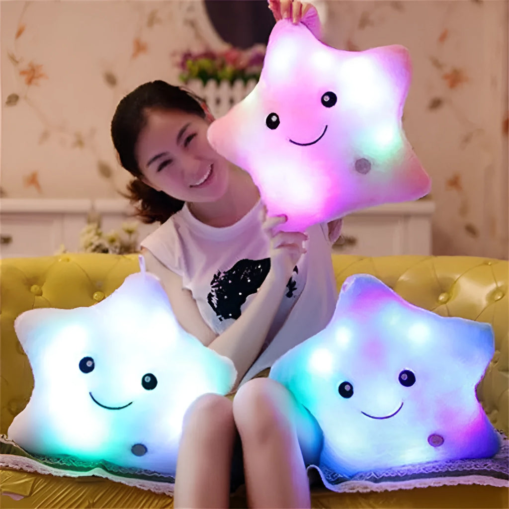 Colourful glowing five-pointed star plush pillow on a dark background, showing soft texture and LED illumination