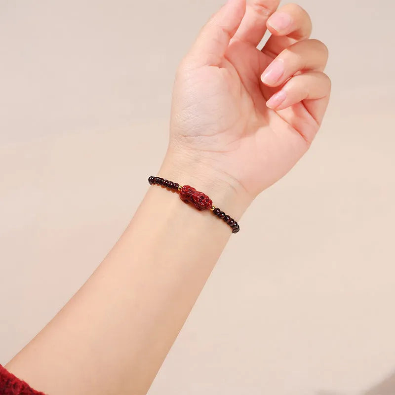 Geometric square garnet bracelet with carved purple pixiu charm on wrist