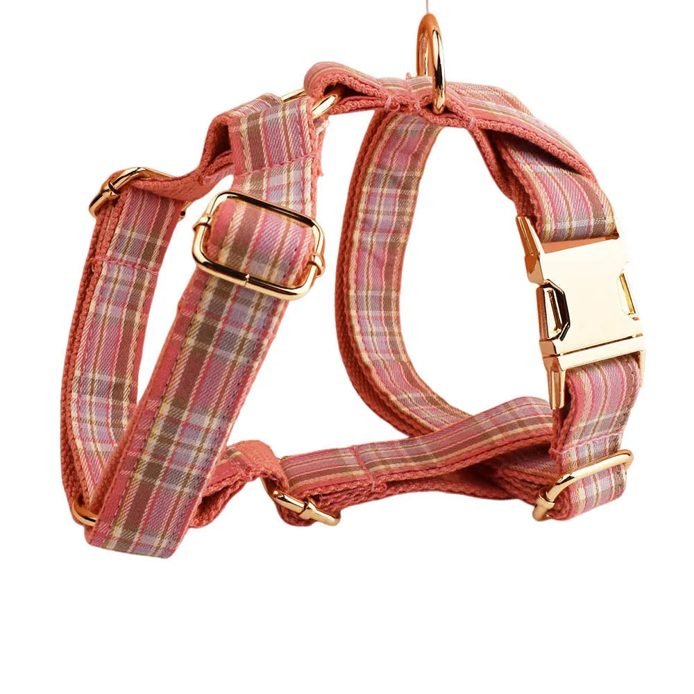 Plaid pattern dog collar and leash set with red bow tie accessory on cloth fabric