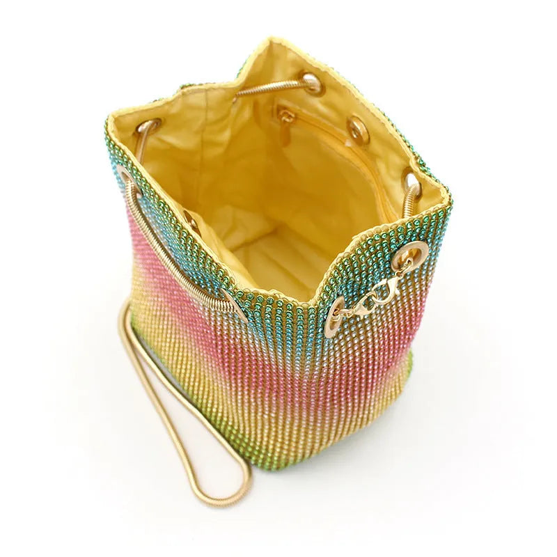 Rainbow coloured rhinestone bucket bag with soft structure and open top, showing sparkling texture.
