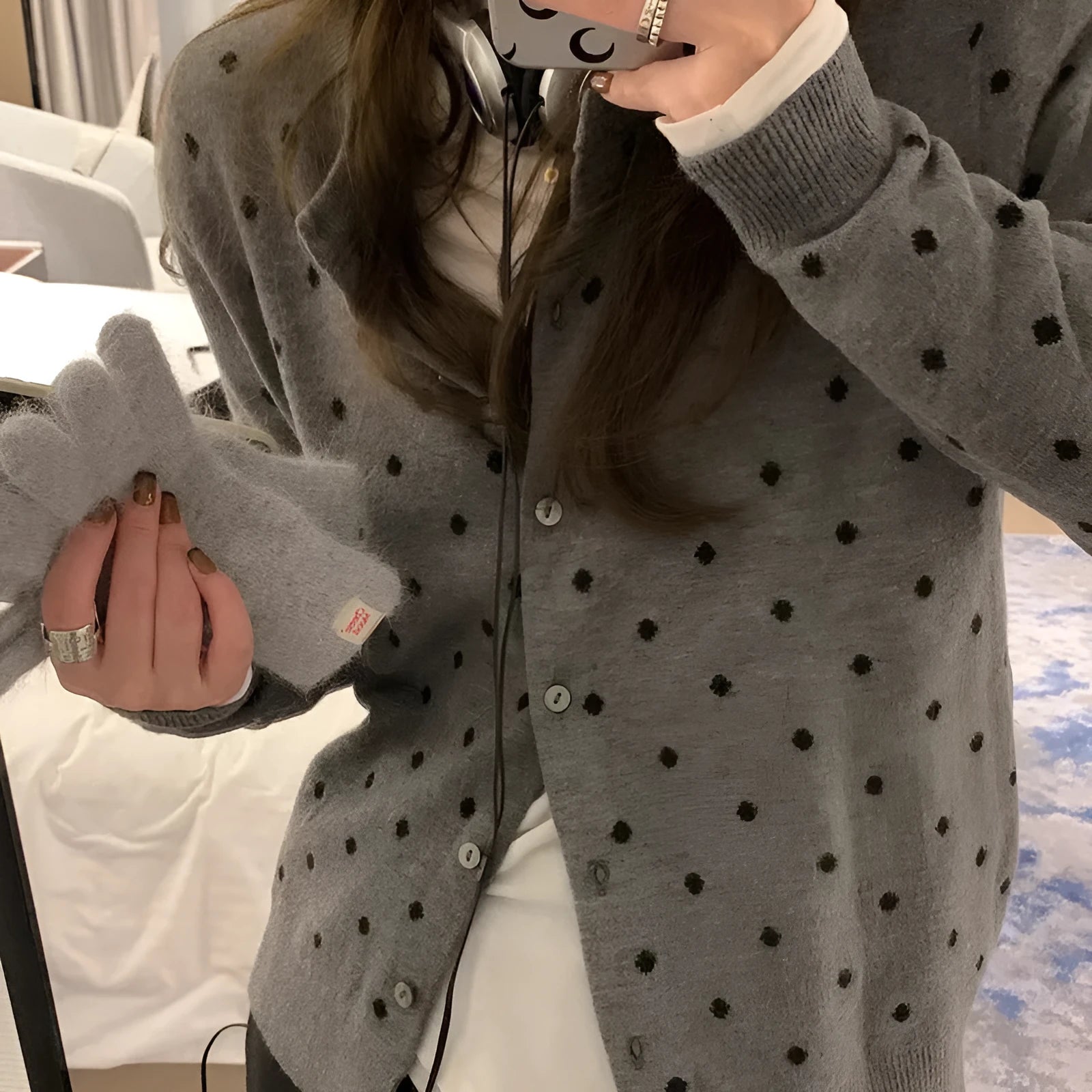 Women's grey dot print knitted cardigan with white crocheted flower detail on sleeve