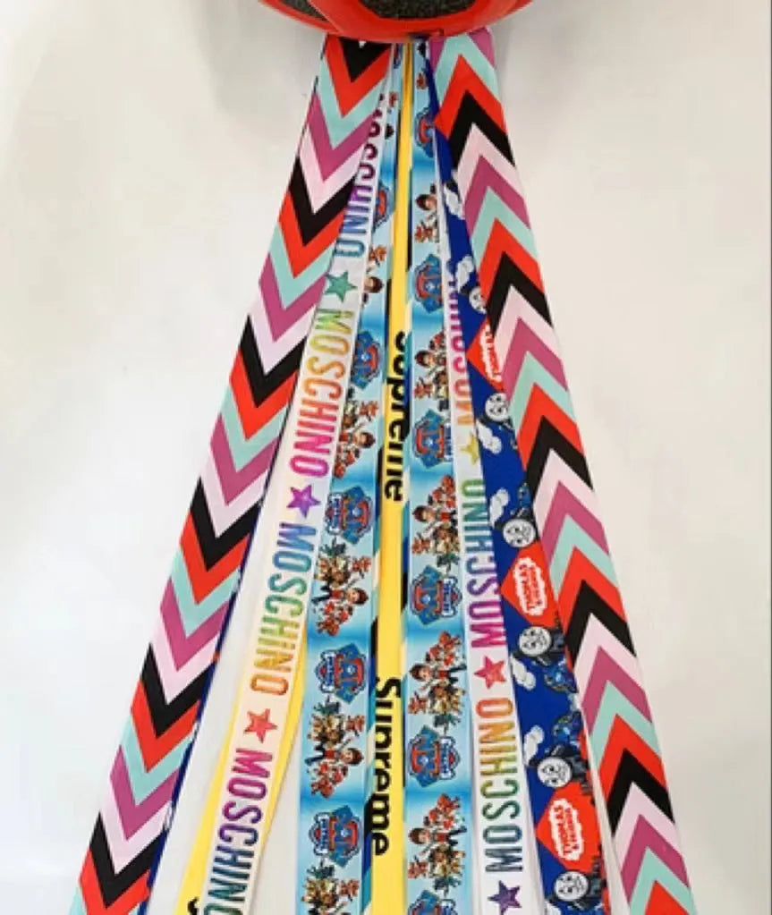 A decorative ribbon streamer for attaching to a child's roller skate or ski helmet, shown in a selection of colours.