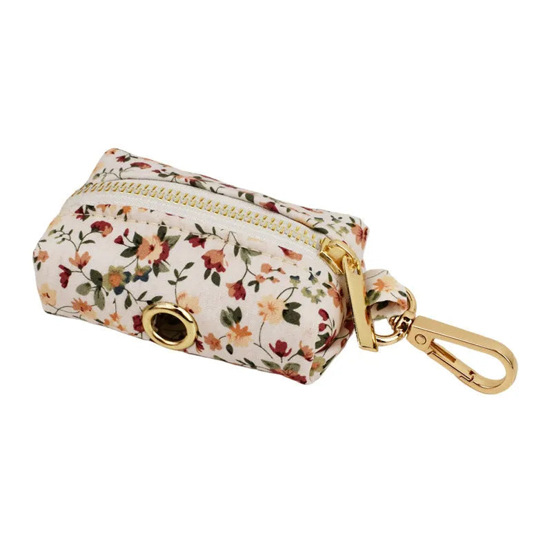 Small white flower pet dog collar set with matching vest, leash, bow, and accessories on a cloth background.