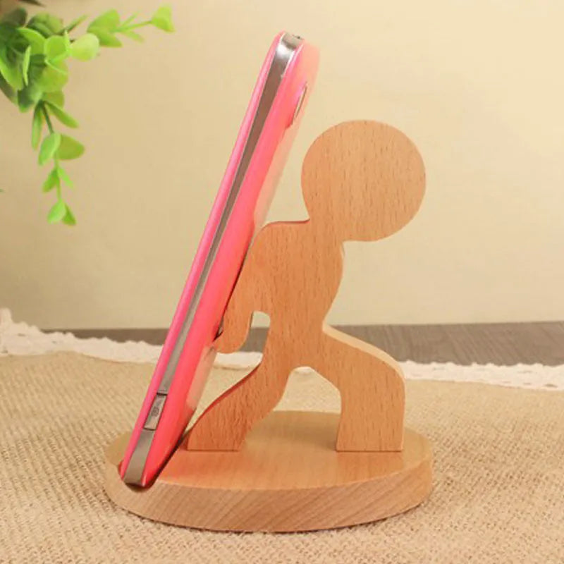 Sculpted beech wood lazy bracket phone holder with custom engraved text on a wooden desk.