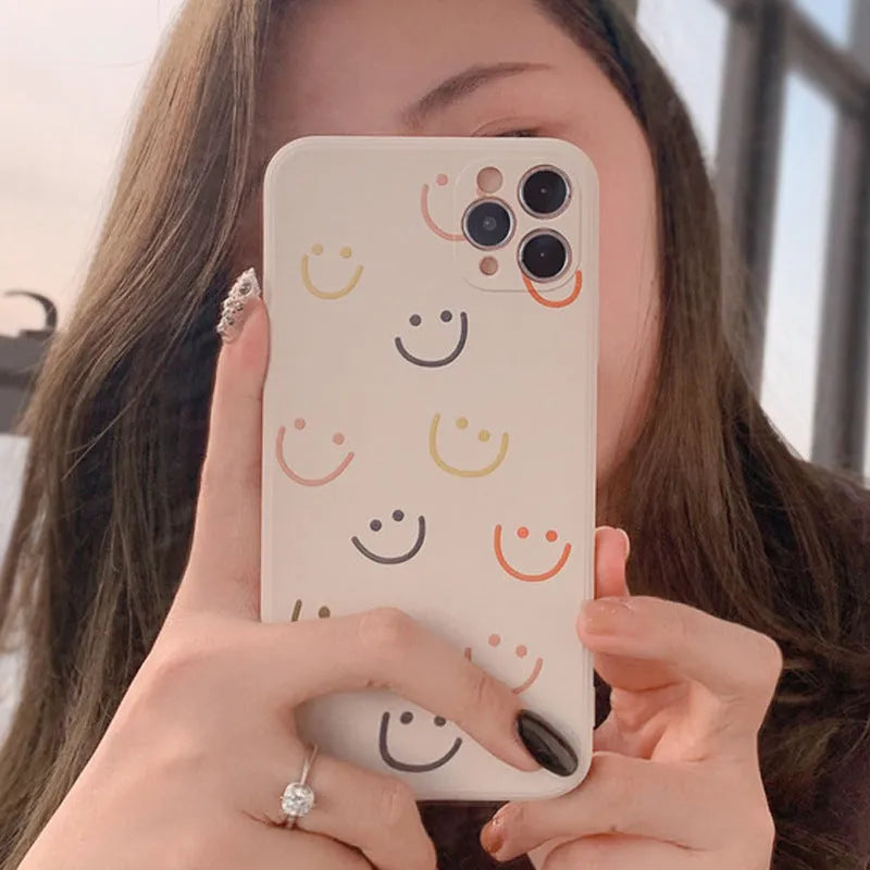 Painted silicone iPhone case showing smiley, rainbow, and watercolour design options