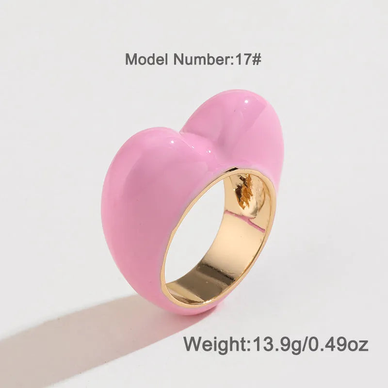 Colourful three-dimensional heart-shaped enamel ring in zinc alloy on a hand.