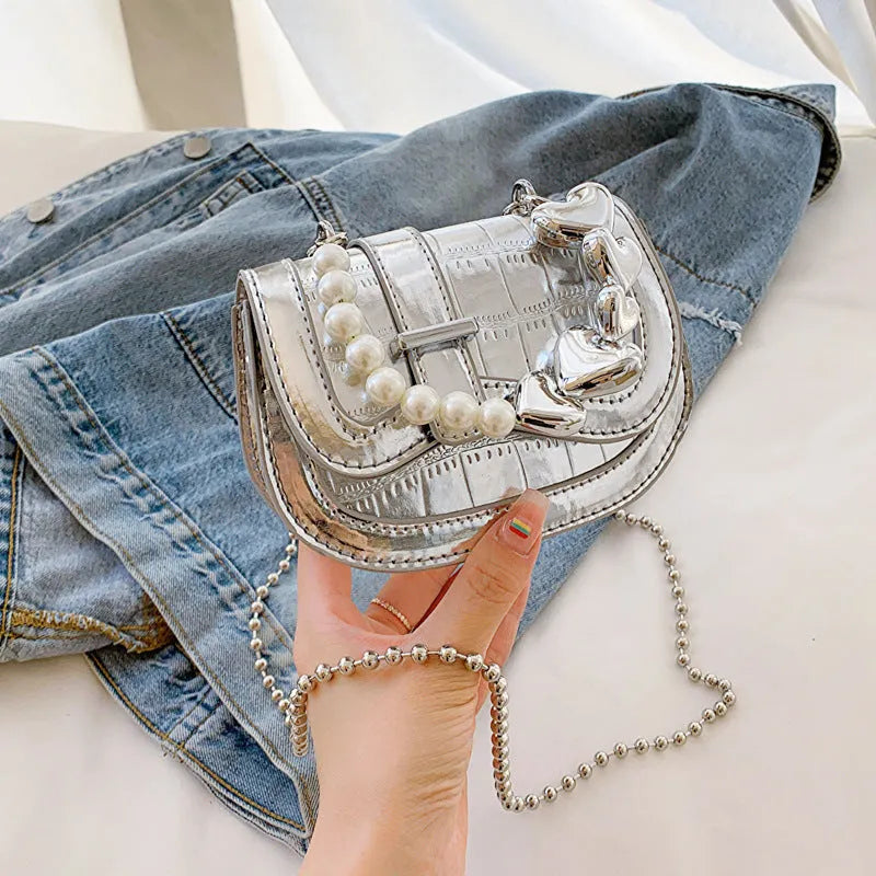 Women's silver mini crossbody bag with a square shape and a single shoulder strap.
