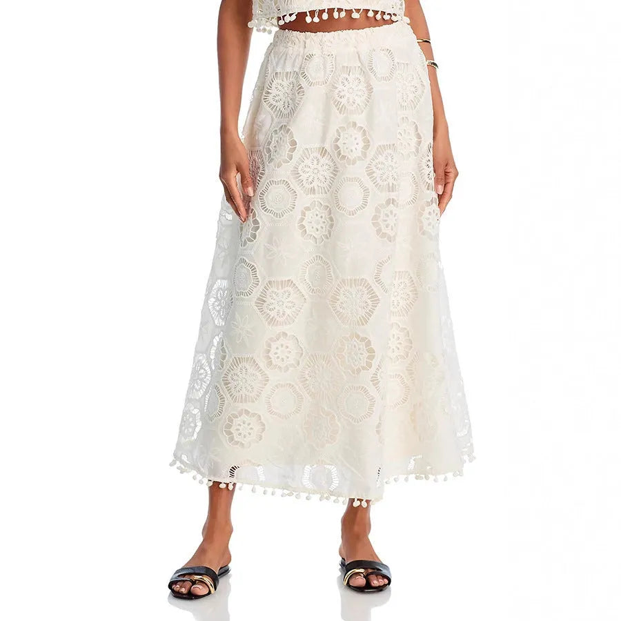 White women's sleeveless top and long skirt set with intricate embroidered retro art design detail.