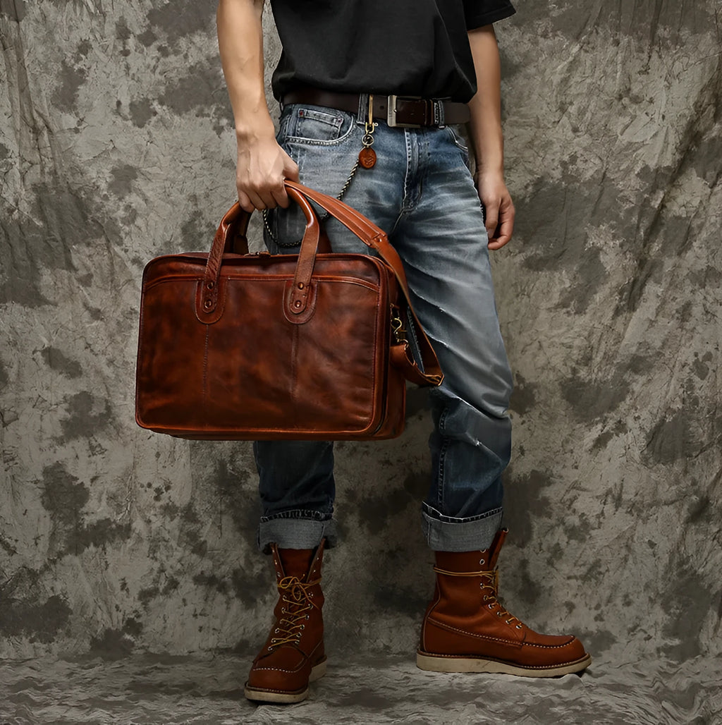 Brown vintage leather men's briefcase showing internal organiser pockets for laptop, documents, and phone.