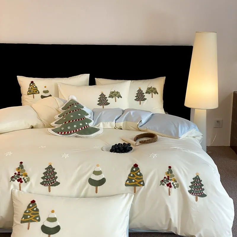 Cream blue cotton duvet cover with embroidered Christmas tree and floral design, laid on a bed with matching pillowcases.