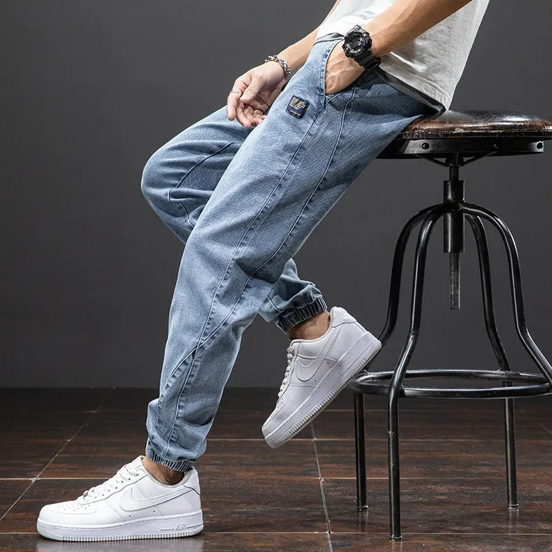Man wearing loose straight-leg cargo jeans in blue, showing Korean-style casual workwear.
