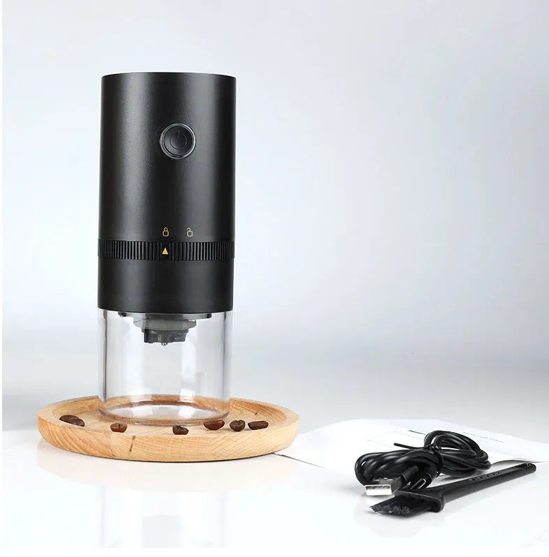 Black and white portable USB-C electric coffee grinder with transparent chamber on a kitchen counter
