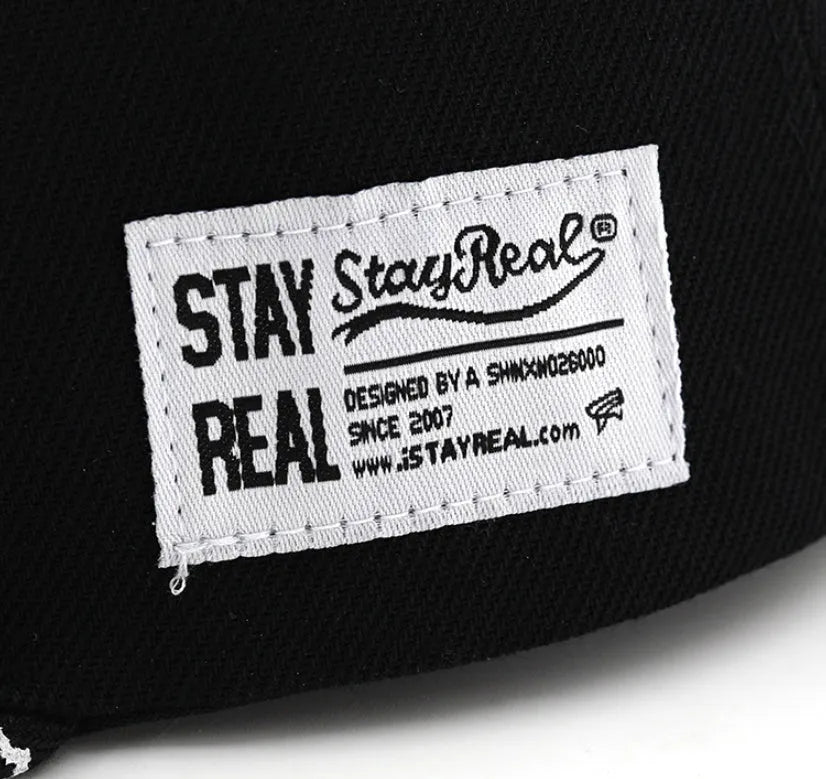 White cotton baseball cap with embroidered lettering on the front, showing the adjustable strap at the back.