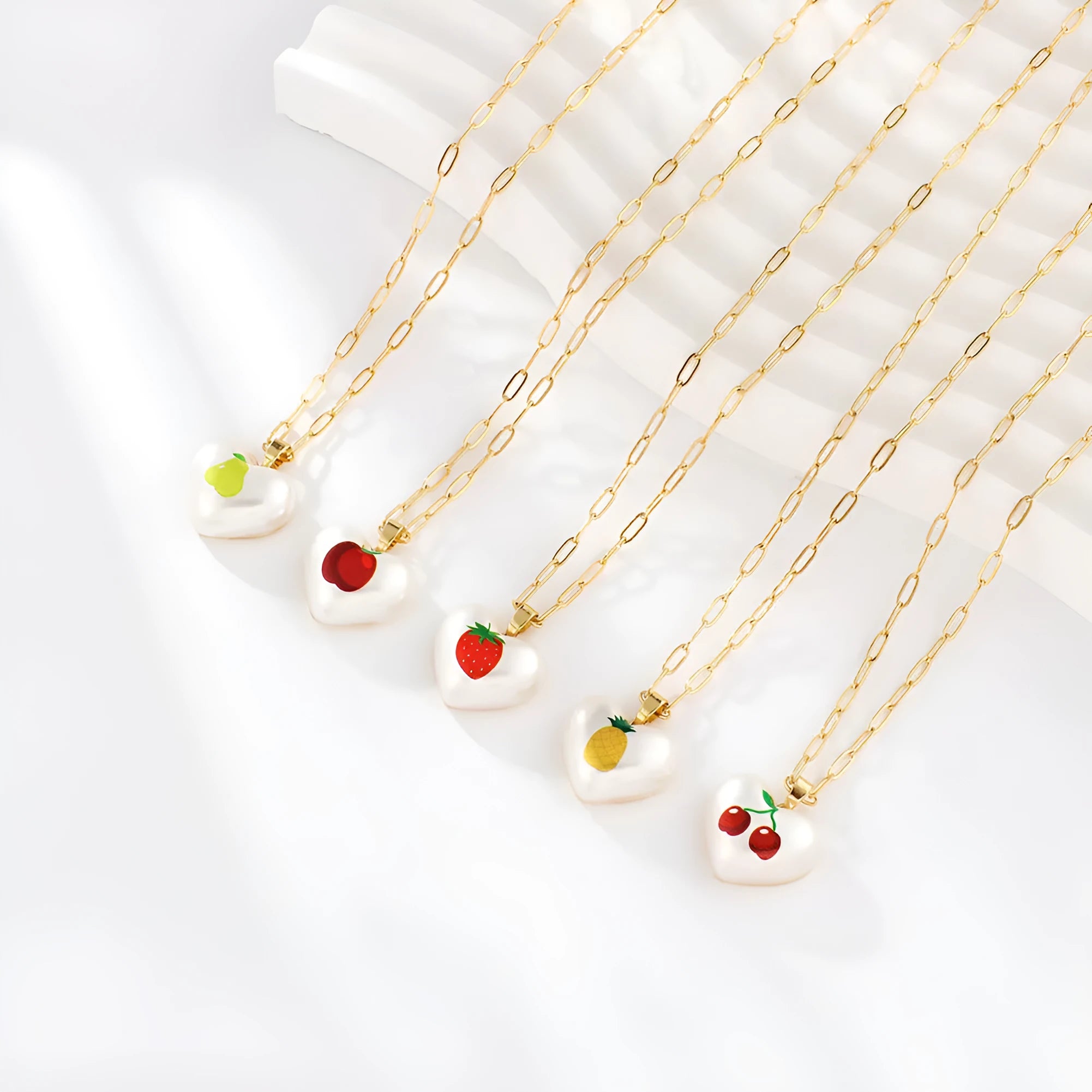 Geometric fruit pendant necklace with adjustable chain showing strawberry pineapple apple pear cherry designs