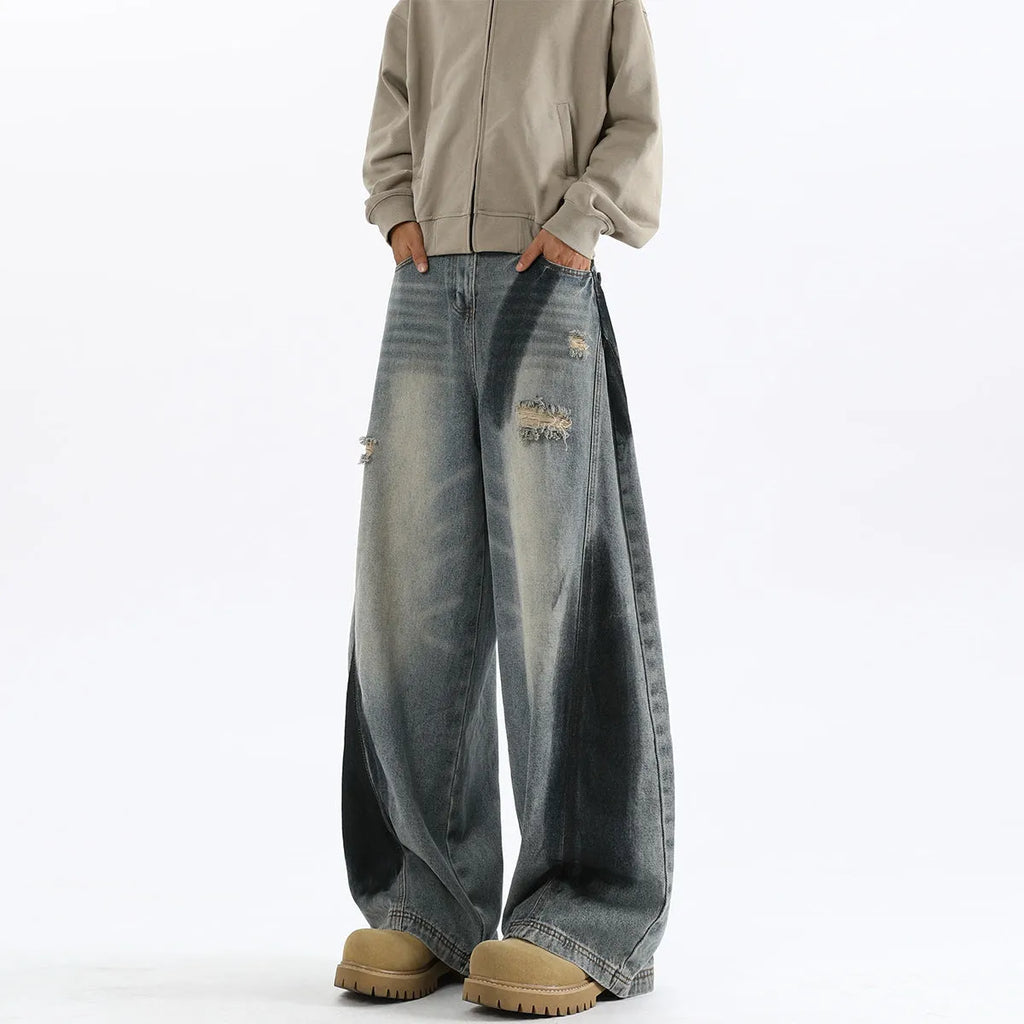 Blue men's loose fit jeans featuring a splash-ink pattern and ripped knee detailing.