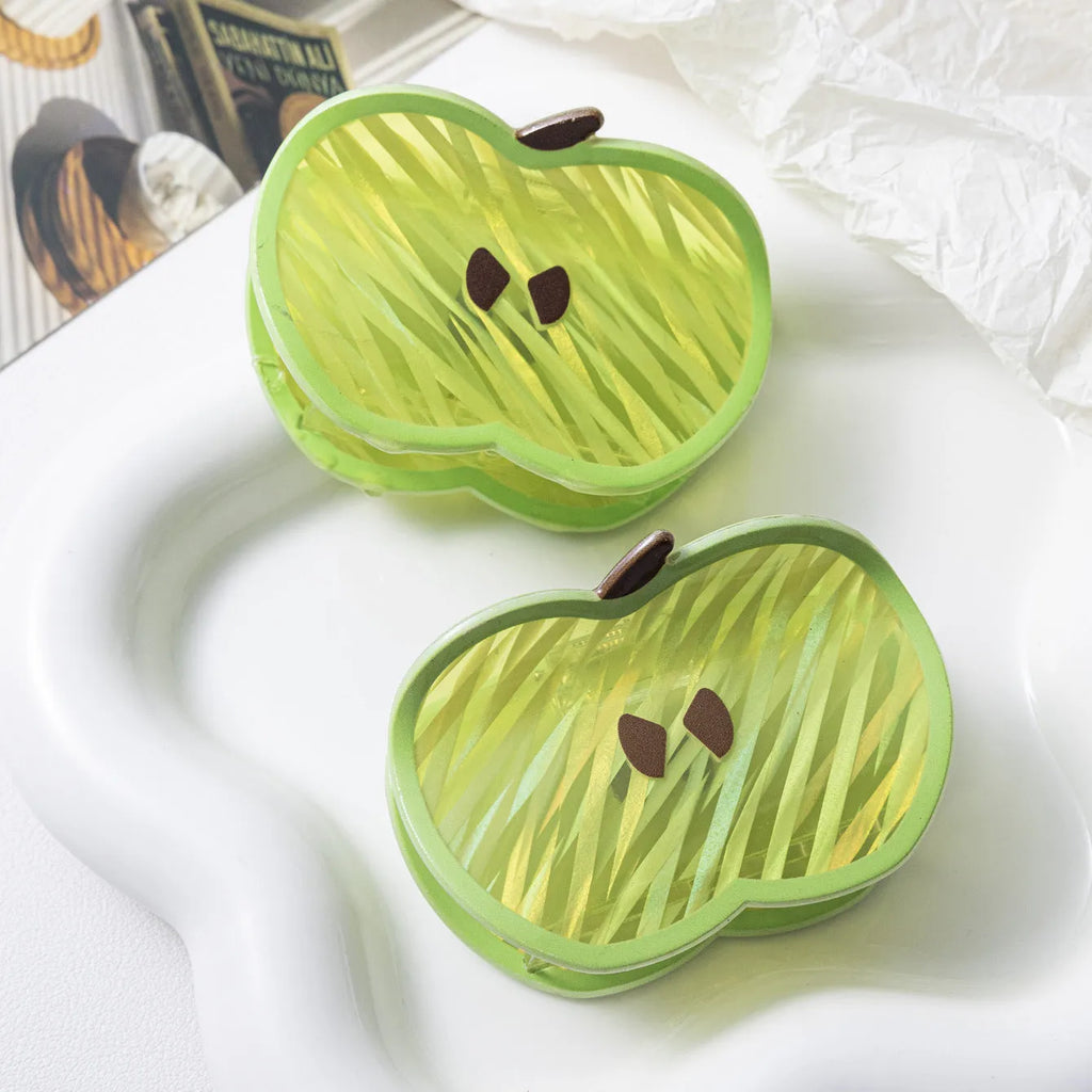 Green apple-shaped claw clip with polished PVC finish, 7.5cm long, on a plain background