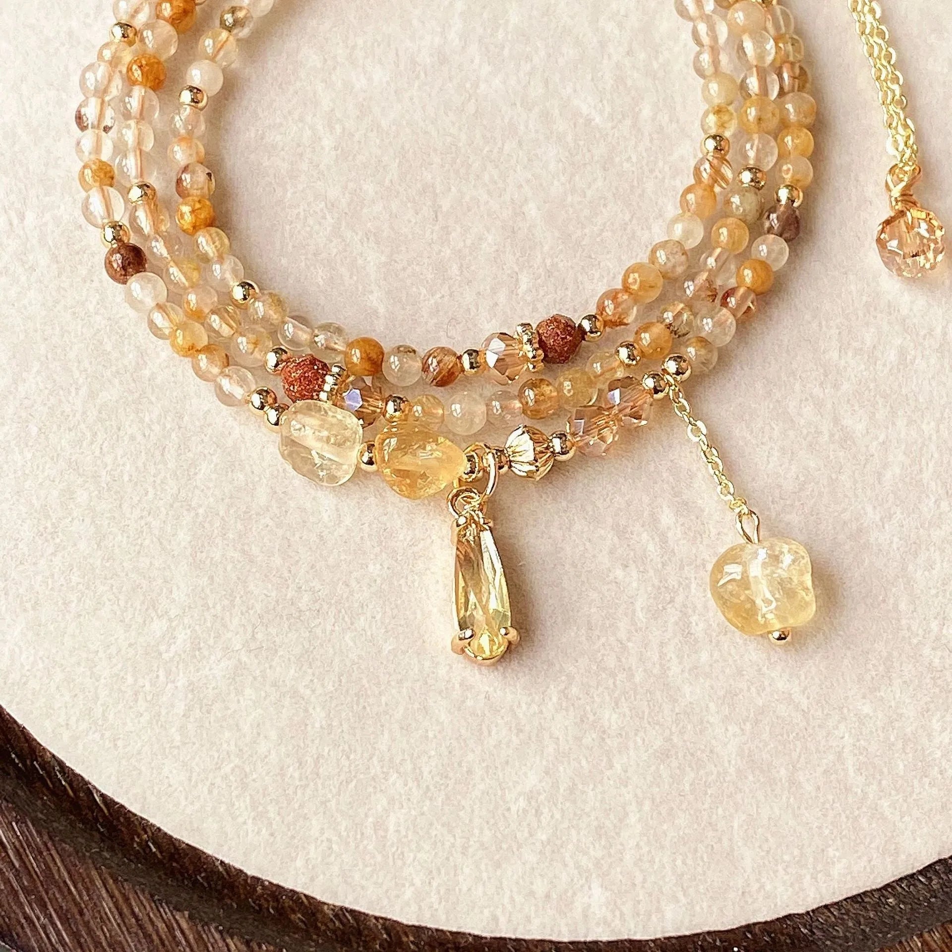 Caramel coloured citrine crystal women's bracelet with multi-layer design and Saturn decorative elements