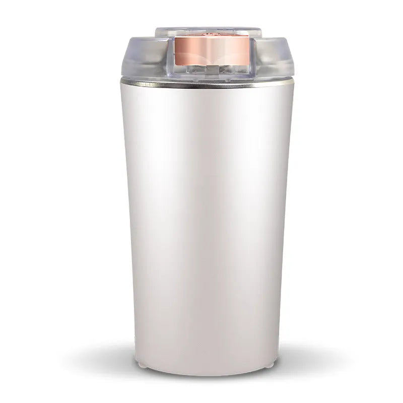 Blue mini flour mill and grain crusher with stainless steel blades on a kitchen countertop.