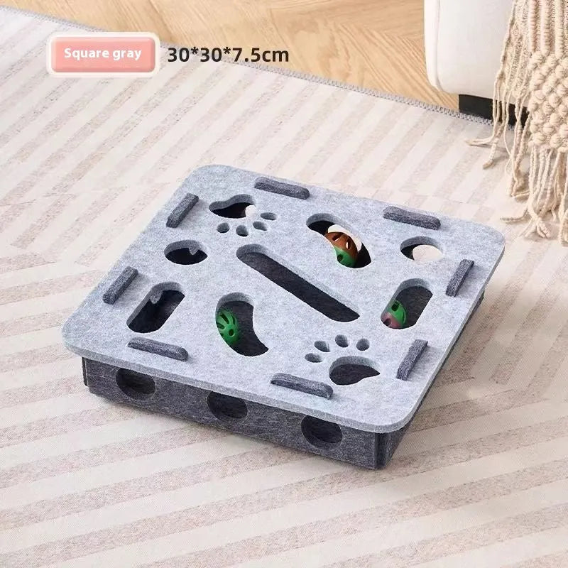 Green brown felt cat toy box with a square hole, measuring 30 cm, on a wooden floor.