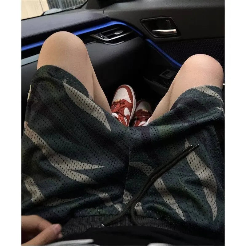 Men's straight-leg camouflage shorts in a cotton blend fabric laid flat.