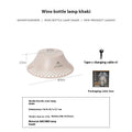 Beige wine bottle camping lantern with USB-C port and gear switch for light modes on wooden table.