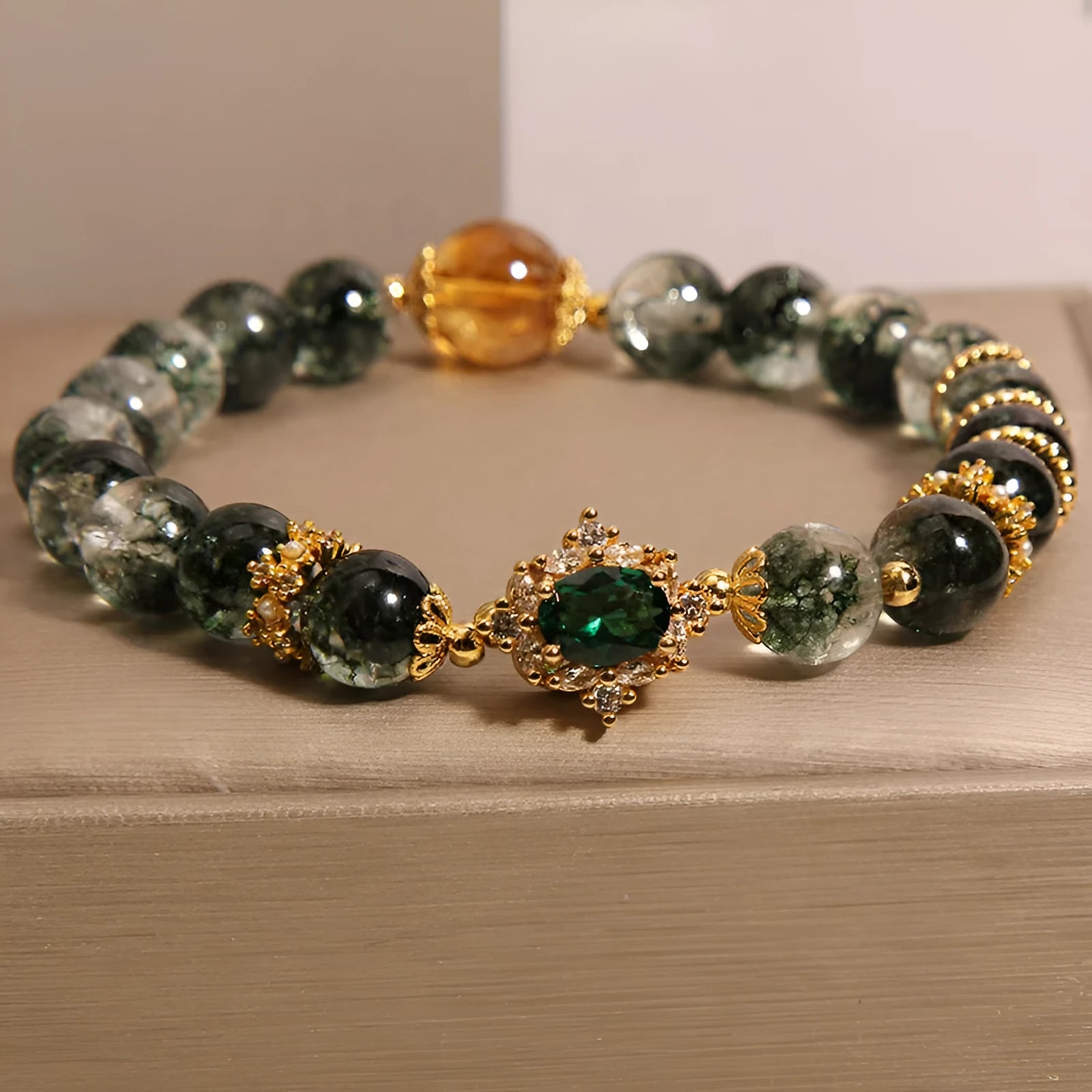 Gold rutilated quartz bracelet with green phantom quartz and ruby quartz crystal beads, pearl accents, and gold-plated detailing