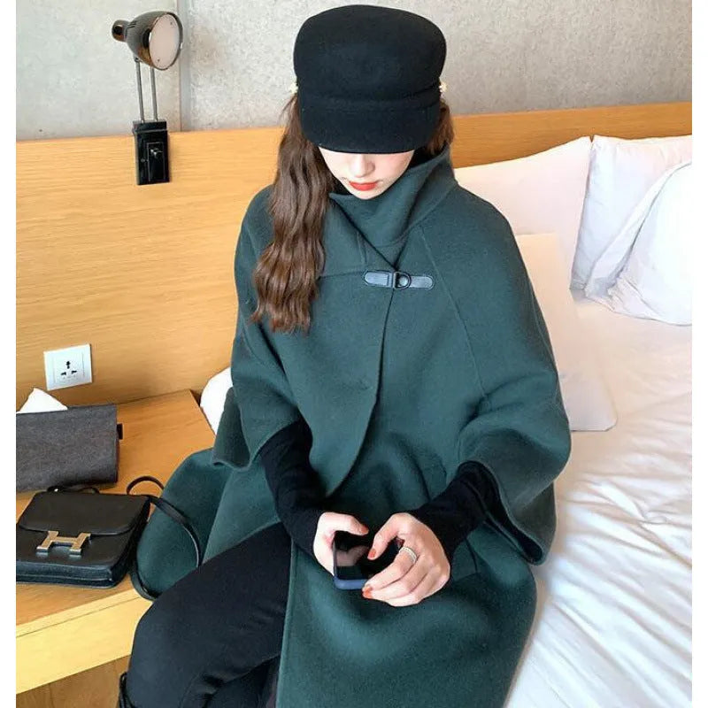 Women's green Korean-style lengthened coat with flight sleeves on a hanger