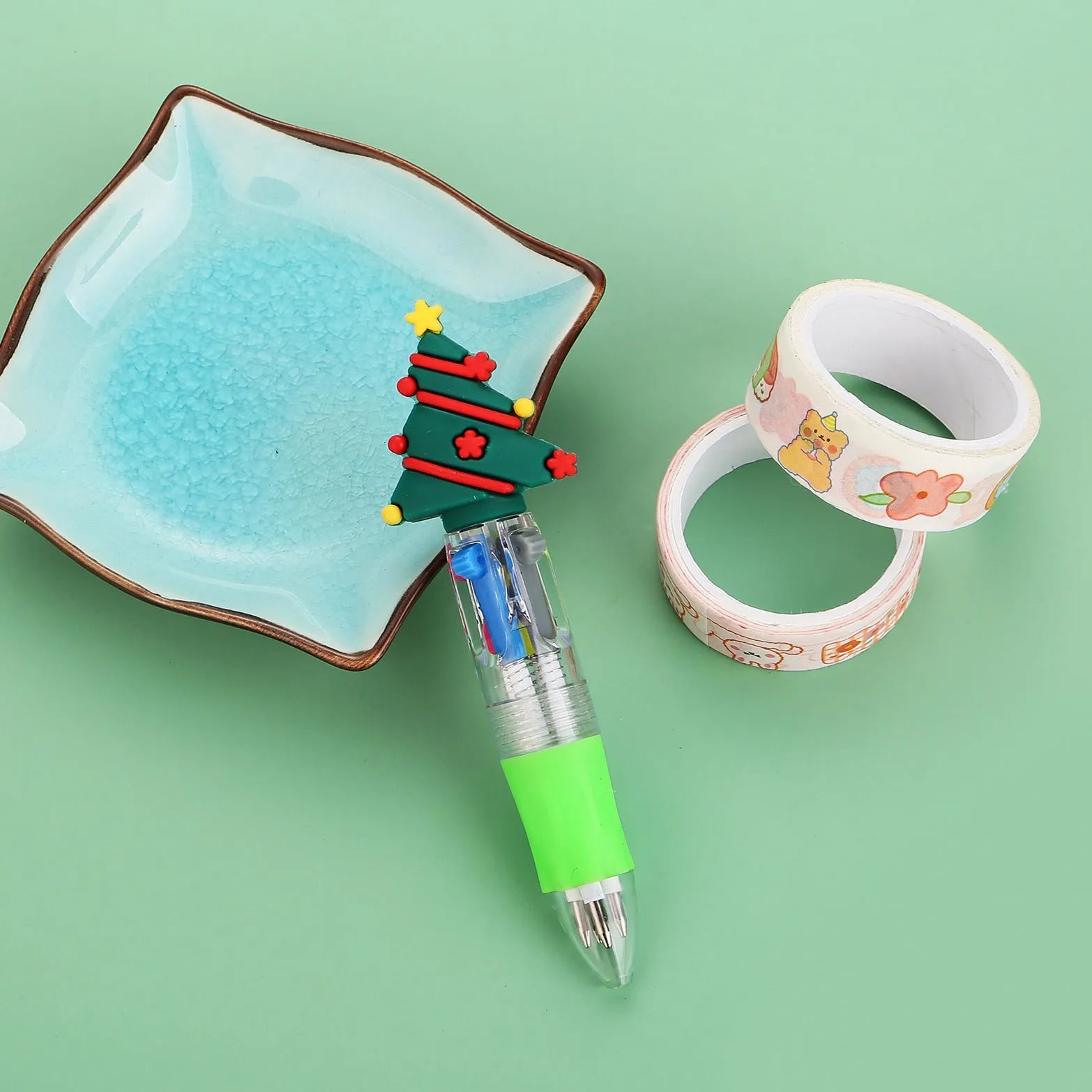 Compact 11cm Christmas ballpoint pen with four colours and festive designs like snowmen and reindeer.