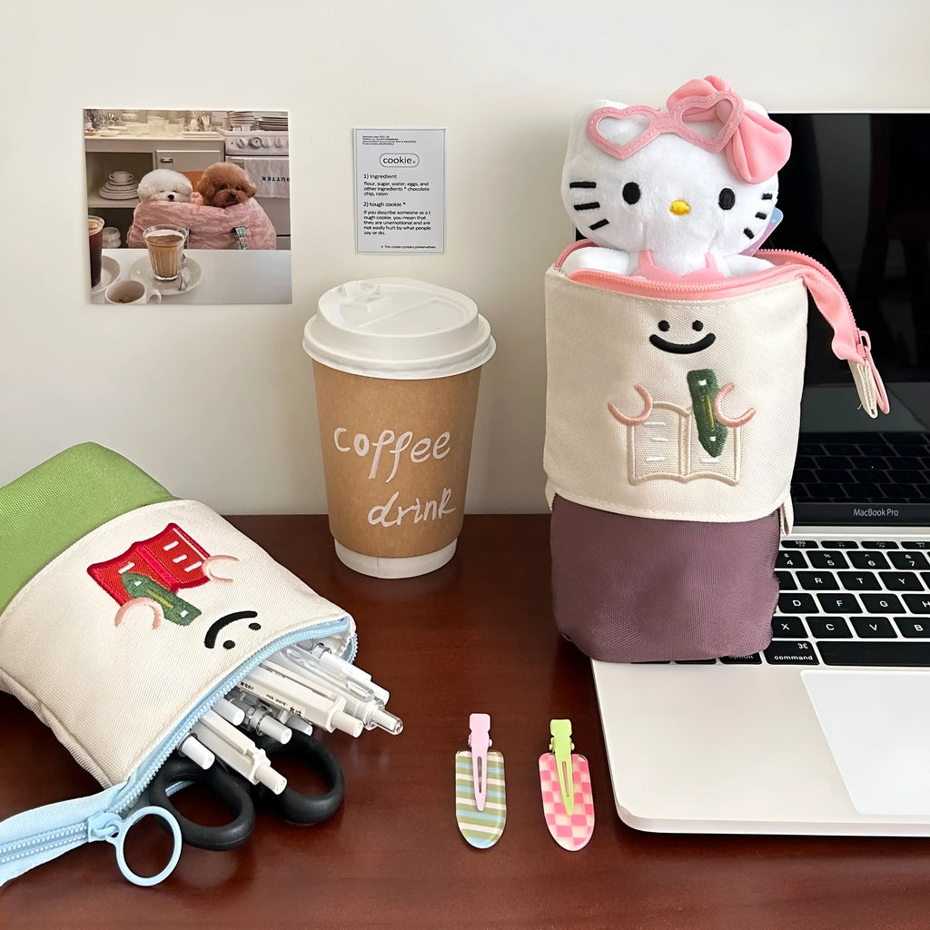 Brown Korean style cartoon print collapsible oxford fabric pencil case open on a table.