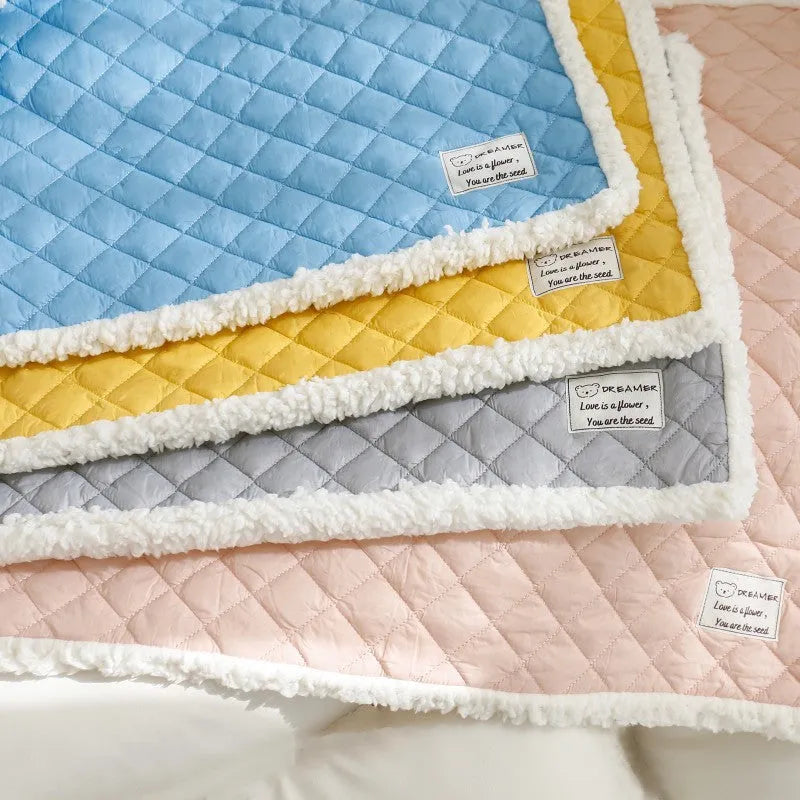 Blue quilted terry cloth cat blanket shown in a pet bed.