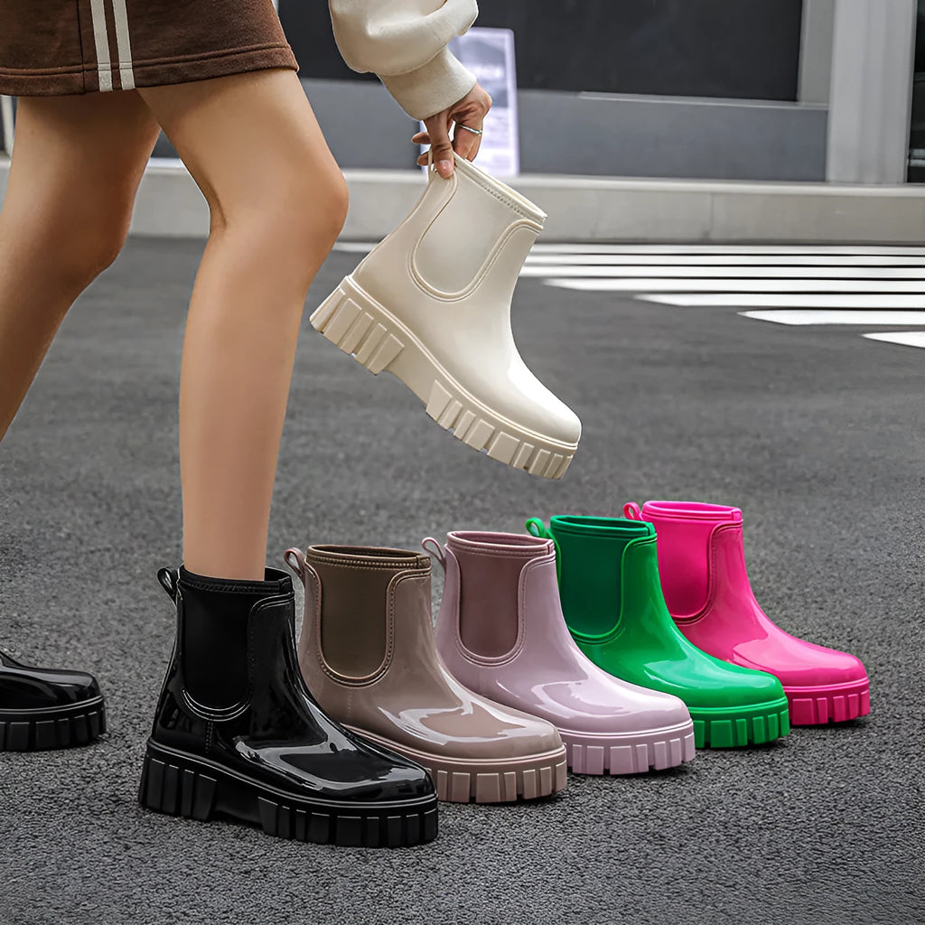 A pair of low tube, flat-heeled PVC rain boots in a solid colour.
