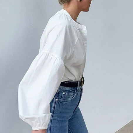 White women's button front long sleeve loose fit polyester shirt on plain background