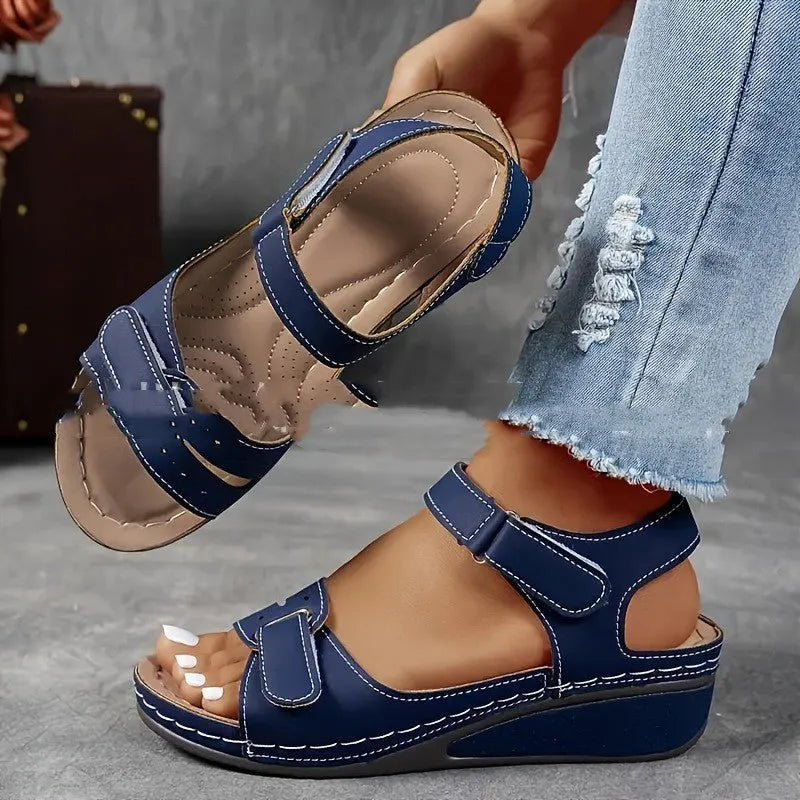 Women's beige thick-soled sandals with adjustable black Velcro straps on a white background.