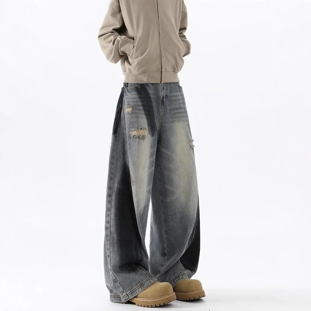 Blue men's loose fit jeans featuring a splash-ink pattern and ripped knee detailing.