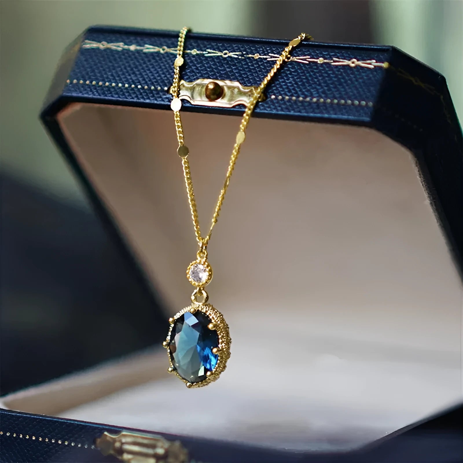 A gold-coloured geometric pendant on a copper chain necklace.
