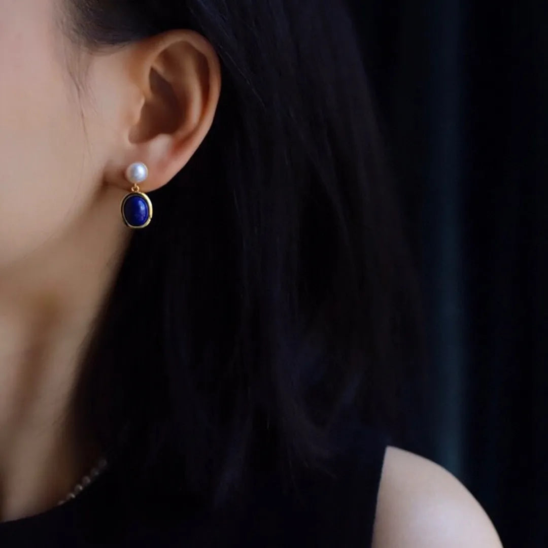 A pair of simple stud earrings with blue lapis lazuli pearls set in silver backs.