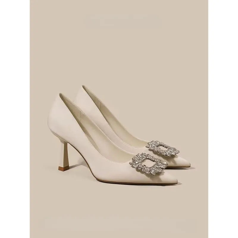 Women's creamy-white pointed-toe stiletto high heels on a plain background.