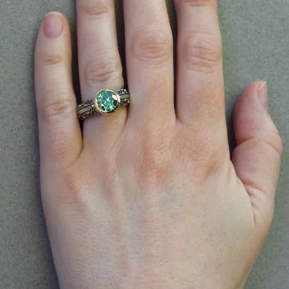 Gold-plated flower-shaped vintage ring with green gemstone and colour separation detailing