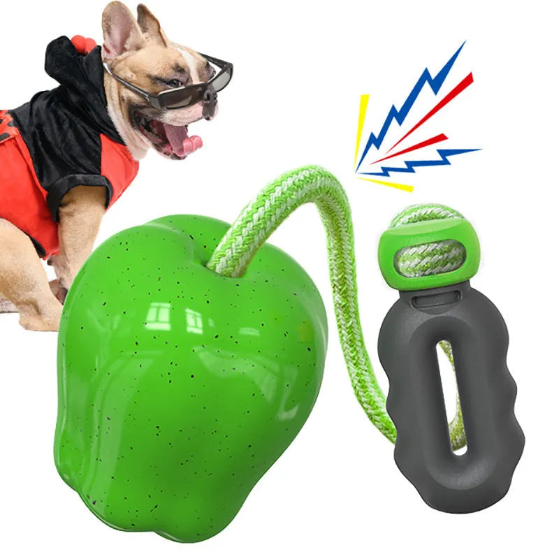 Green and red plastic dog dropping ball toy for treat dispensing and outdoor play.
