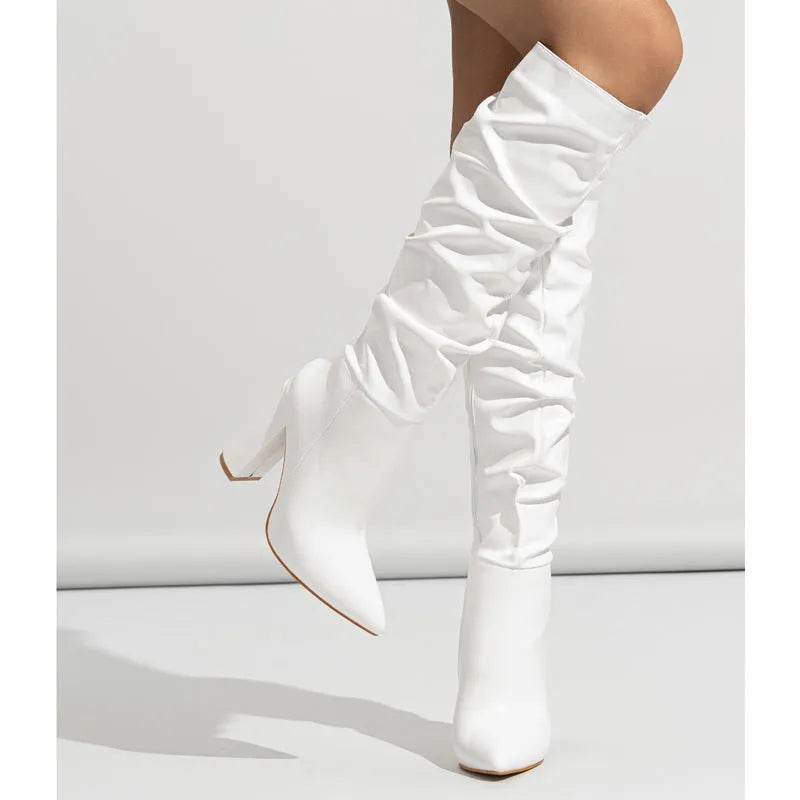 White women's pointed toe high heel boots with side zipper on a model.