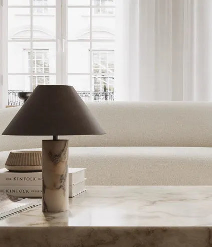 Black modern minimalist table lamp with a solid marble base on a wooden surface.