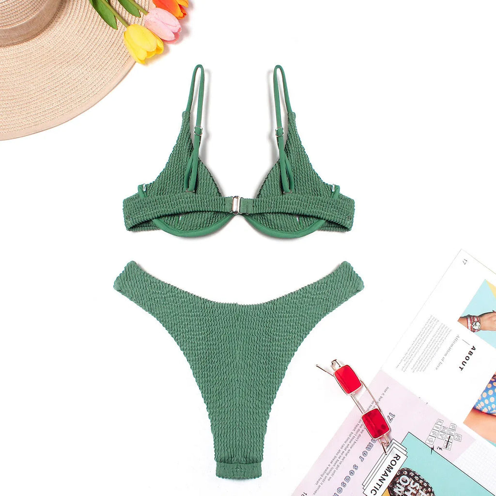 Women's solid green bikini suit with ruffle trim and split leg briefs on a mannequin.