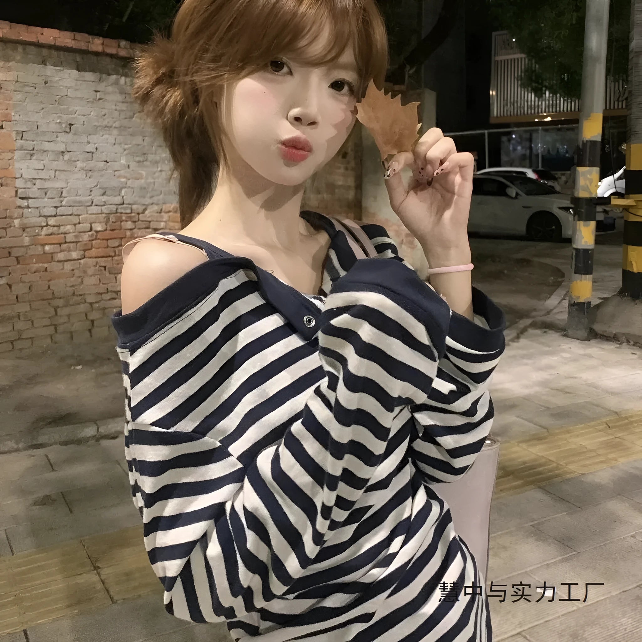 Dark blue women's oversized long-sleeve T-shirt with embroidered stripes and button details.