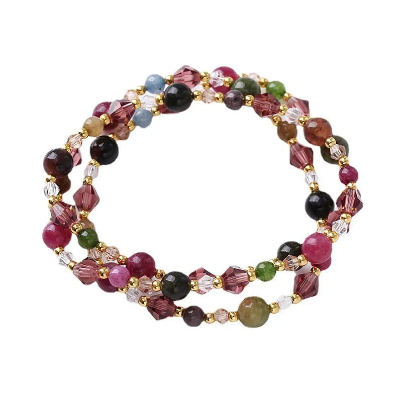 Women's three-ring crystal bracelet with tourmaline, strawberry quartz, and amethyst stones on adjustable rope