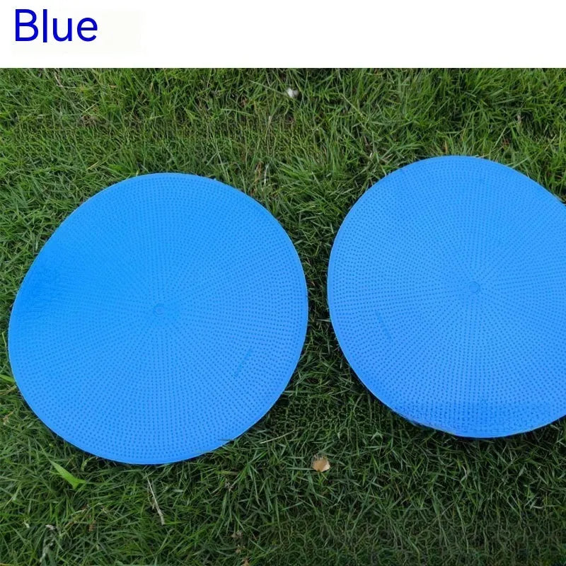 Soft yellow TPE football training target pad flat on grass, 23cm diameter.