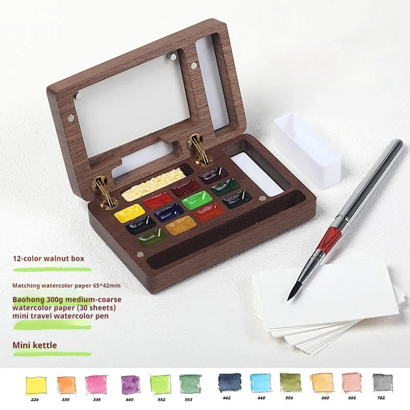 Mini walnut-finished wooden watercolour paint box open to show pigment suit pans inside.