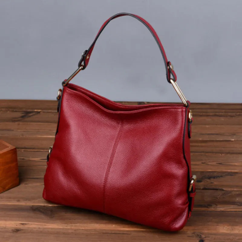 Genuine leather vertical square crossbody bag in black with sewing line detail and external pocket.