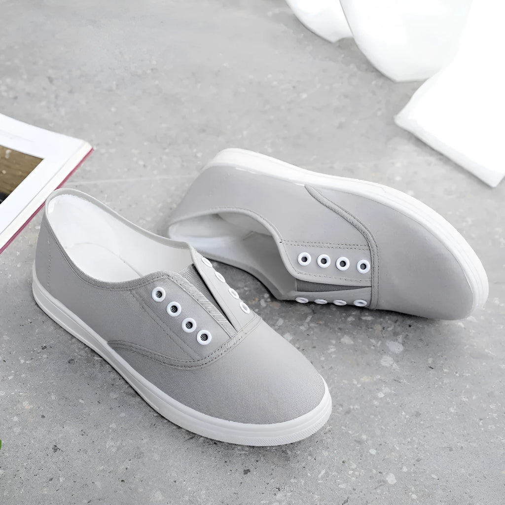 Low-top casual canvas shoes on a flat heel, shown in various colours including black, white, grey, and pink.