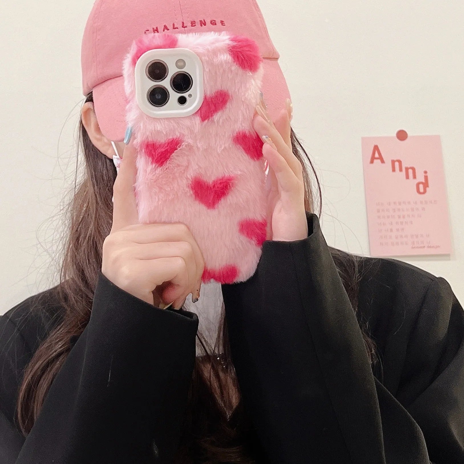 Pink silicone iPhone case with cartoon Love Plush design, shown fitted on a mobile phone.
