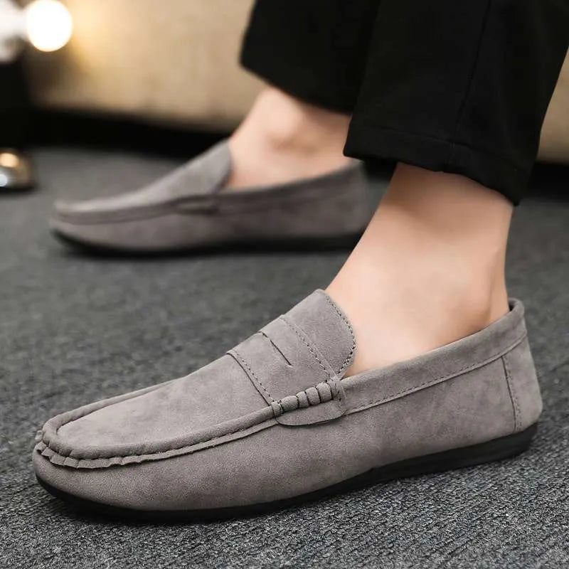 Men's black slip-on shoes with round toe, grape particle detail, and rubber sole.